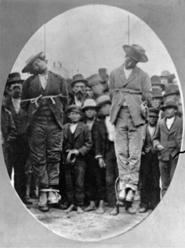 Foto tomada del libro "Forgotten Dead". En la imagen, un par de hombres descendientes de mexicanos son observados por la multitud después de ser linchados en la localidad de Santa Cruz, California.
